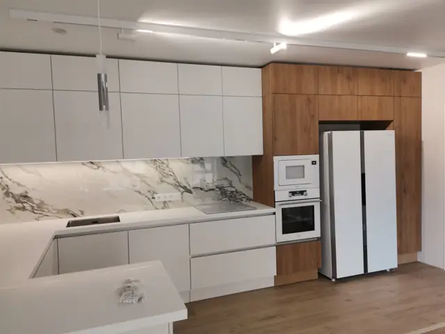 Кухня с мраморным фартуком и встроенной техникой